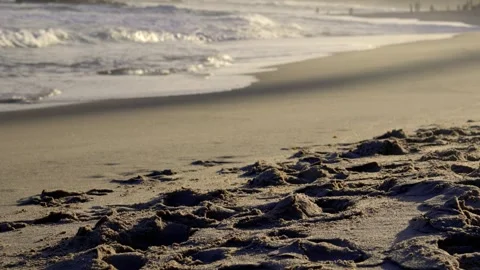 Low angle view of footsteps in wet sand with ocean waves washing ashore in Salva Vidéo 319206808