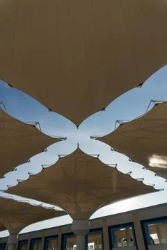 Low angle view of giant mosque courtyard umbrellas under blue sky Stock Photos