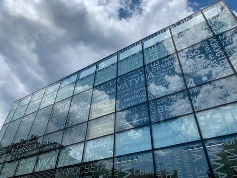 Low angle view of glass facade reflecting the sky.  Stock Photos