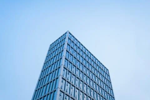Low angle view of glass facade of tall office building against clear blue sky Fotos de archivo