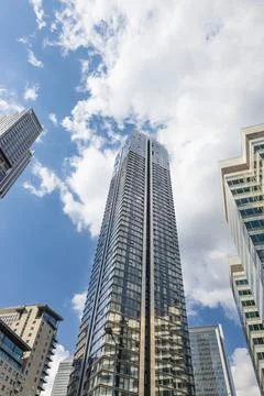 Low angle view of glass skyscraper against blue sky Stock Photos