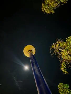 Low Angle View of a Glowing Street Lamp and Full Moon Against Night Sky with Stock Photos