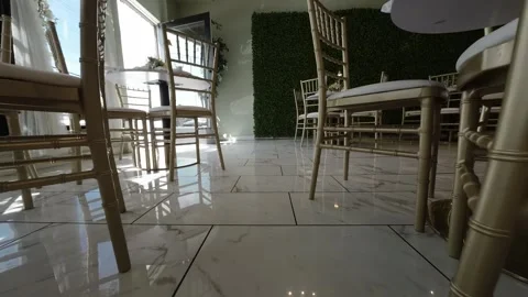 Low angle view of gold chairs and tables on a marble floor Stock Footage 345561485