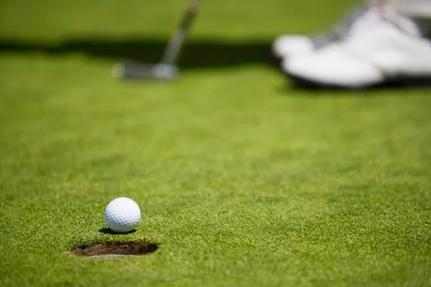 Low angle view of golf ball rolling towards cup Foto stock