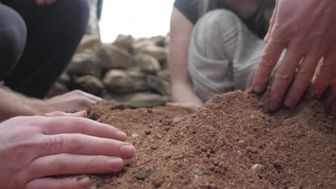 Low angle view of hands removing red construction sand. 스톡 동영상 241841450
