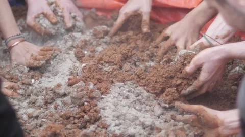 Low angle view of hands removing red construction sand with cement. 스톡 동영상 241841465