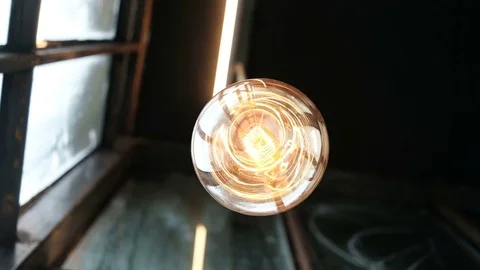 Low angle view of hanging orange light bulb stagger Vidéo 82475234
