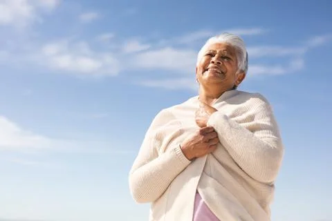 Low angle view of happy biracial senior woman holding shrug looking away at Stock Photos