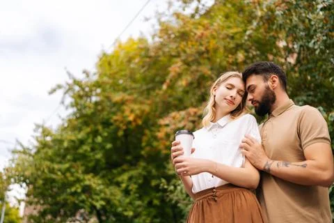 Low-angle view of happy young couple in love standing hugging with closed eyes Stock-Fotos