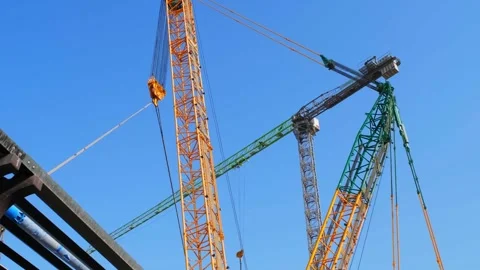 Low angle view of heavy-duty tower and crawler construction cranes operatin.. Stock Footage 348064473