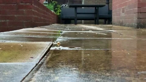 Low angle view of heavy rain falling onto a patio area. Stock Footage 136819311