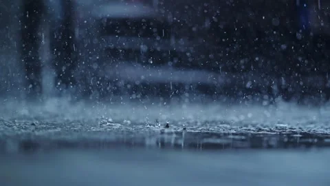 Low angle view of heavy rain splashing on pavement in parking lot scene Stock Footage 315077444