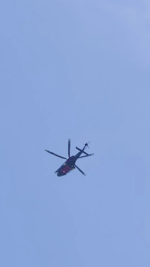 Low angle view of a helicopter flying across a blue sky with scattered clou.. Stock Footage 332792053