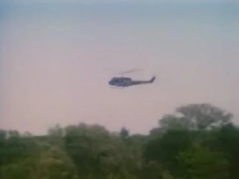 Low angle view of helicopter preparing to descend in open field, 1980s Stock Footage 61766880
