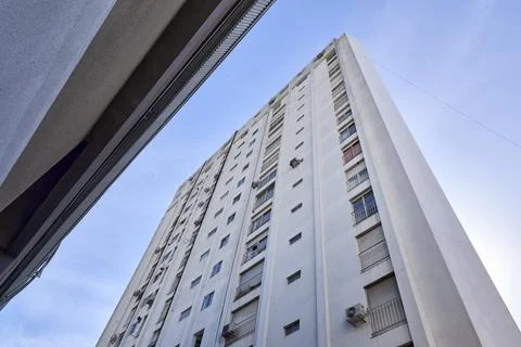Low angle view of high concrete building with many windows and vertical lin.. Stock Photos