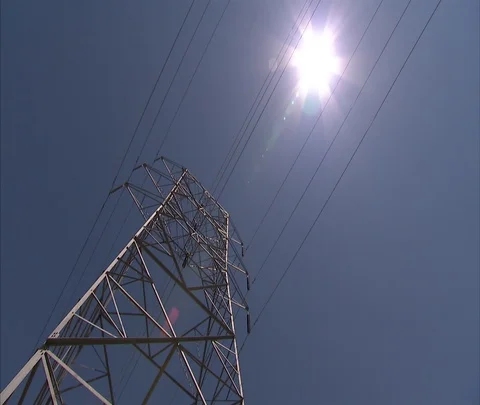 Low angle view of high voltage power lines with sun Stock Footage 86691582