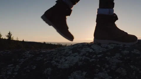 Low angle view of hiker boots walking to edge of mountain cliff at sunrise. 스톡 동영상 334560653