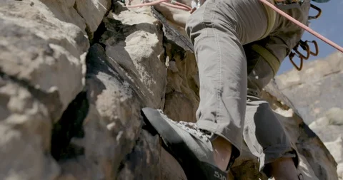 Low angle view of hiker rock climbing on the rocky mountain edge Stock Footage 145281152