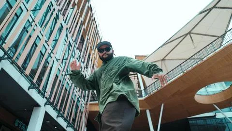 Low angle view of hipster pose in hip hop style surrounded by mall. Endeavor. Photos