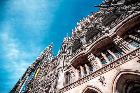 A low angle view of a historic building with a tall spire against a bright blue Stock Photos