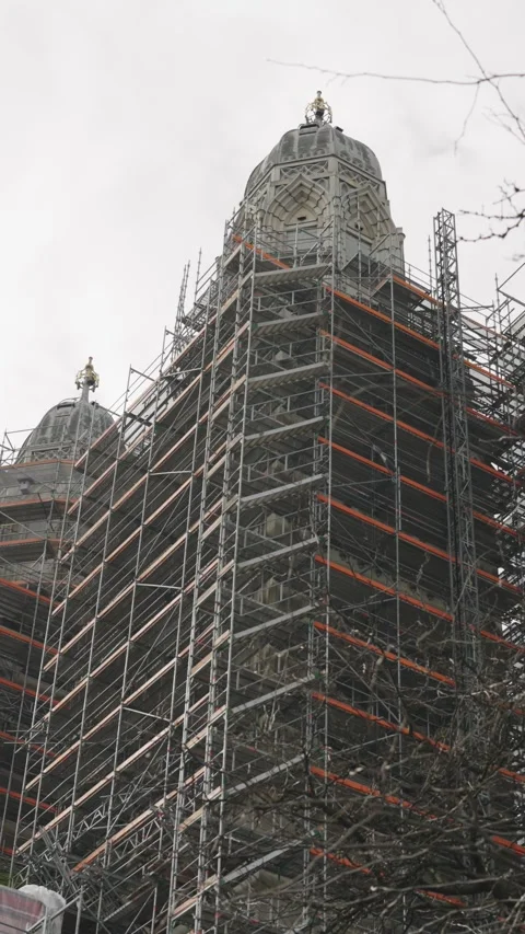 Low angle view of a historic church tower covered in extensive scaffolding 스톡 동영상 332710265