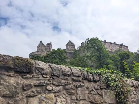 Low angle view of historic Edinburgh Castles fortress walls against a cloudy Stock Photos