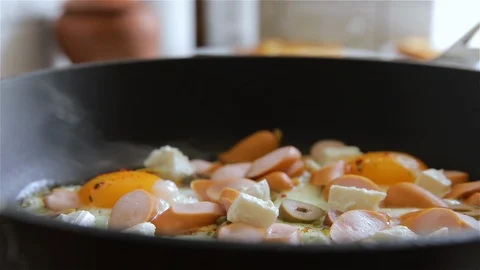 Low Angle view of a hot frying pan. Eggs are frying. The process of making an om Stock Footage 126608996
