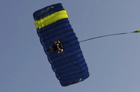 Low-angle view of human parasailing in the blue sky - extreme sport Stock Photos