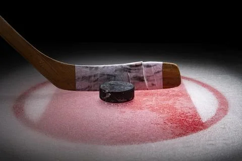 Low angle view of an ice hockey stick with puck sitting on the Face Off Spot in Foto stock