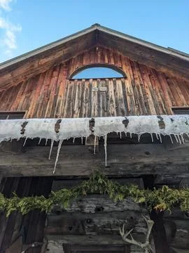 Low Angle View of Icicles on Rustic Wooden Cabin in Winter 스톡 사진