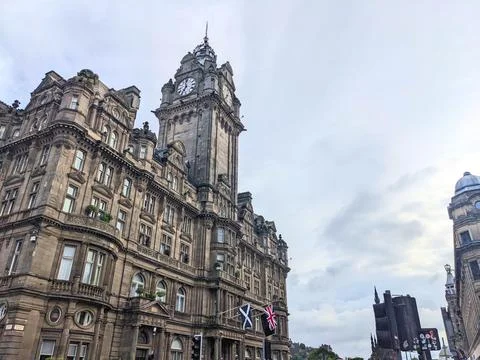 Low angle view of the iconic Balmoral Hotel clock tower against a cloudy sky in Stock Photos