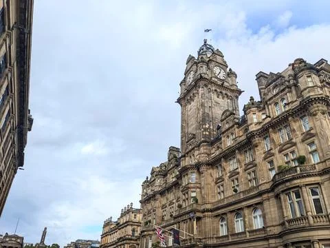 Low angle view of the iconic Balmoral Hotel clock tower against a cloudy sky in Stock Photos