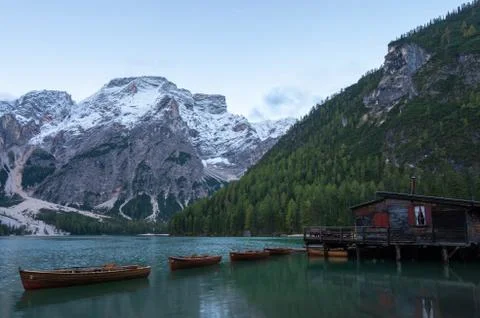 Low angle view of iconic boathouse and boats with mount Seekofel mirroring in Stock Photos
