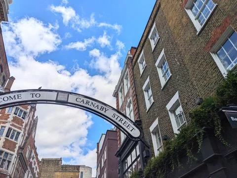 Low angle view of the iconic Carnaby Street sign against a bright blue sky in Stock Photos