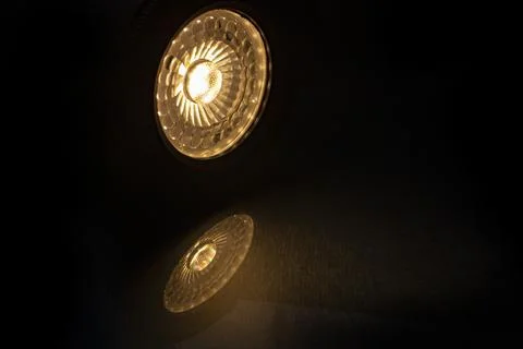 Low-angle view of an illuminated warm white GU10 LED ceiling lamp casting a.. Stock Photos