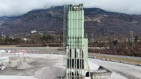 Low angle view of industrial cement silo with highway and mountains background 스톡 동영상 329933200