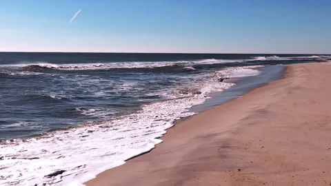 A low angle view of a large flock of sandpipers flying over an empty beach Stock Footage 264802628