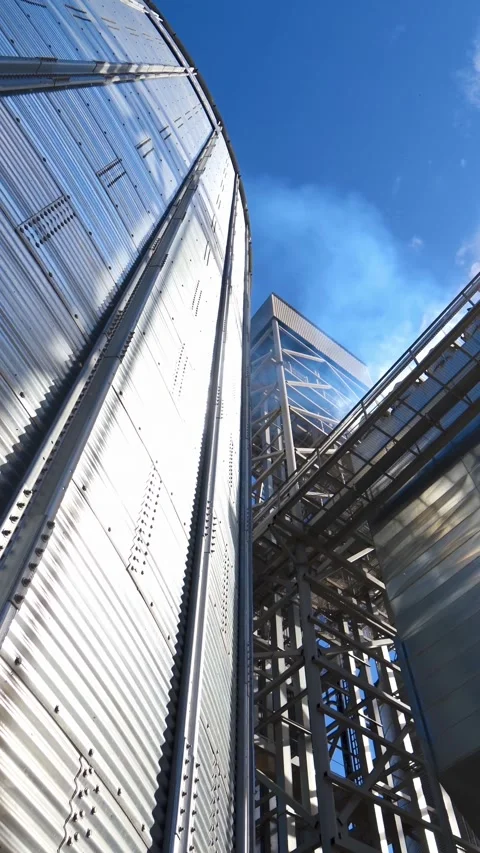 Low angle view of large grain elevator and corrugated metal storage bins at.. Stock Footage 337545320