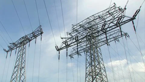 Low angle view of large power lines and electrical pylons against a blue sky Stock-Footage 332873918
