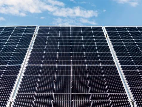 Low angle view of large solar panel against blue sky. Stock Photos