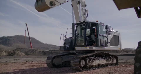 Low angle view of large white hydraulic crawler excavator at construction site Stockbeeldmateriaal 329560781