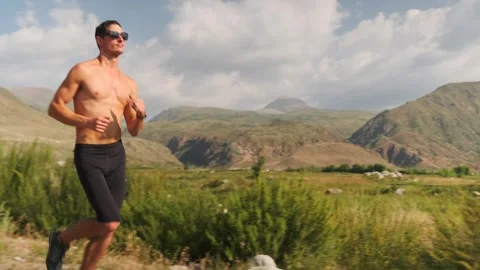 Low angle view of a lean, muscular runner speeding through slopes. Stock Footage 301494955