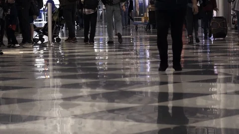 Low angle view of legs in crowds walking down a terminal at O'Hare Airport Stock Footage