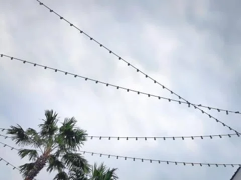 Low Angle View of Lightbulbs with Cables Against Cloudy Sky Stock Photos