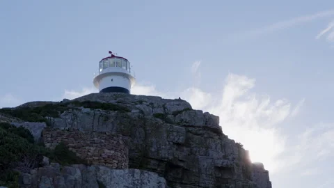 Low angle view of a lighthouse atop a steep, rocky cliff face. Stock Footage 242013384