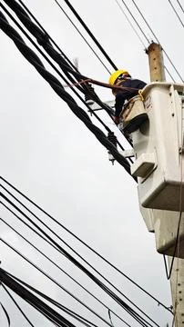 Low angle view of lineman electrician worker in bucket truck basket. Stock Photos