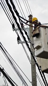 Low angle view of lineman electrician worker in bucket truck basket. Stock Photos