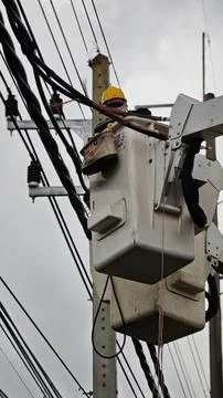 Low angle view of lineman electrician worker in bucket truck basket. Stock Photos