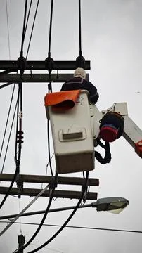 Low angle view of lineman electrician worker in bucket truck basket. Stock Photos