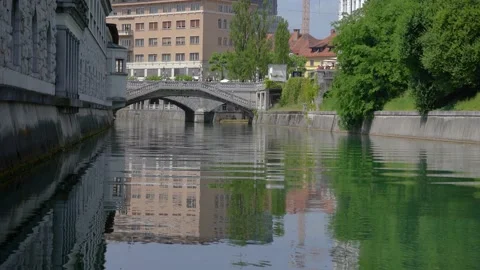 Low angle view of Ljubljanica river and famous Triple Bridge in Ljubljana city Stock Footage 157495609